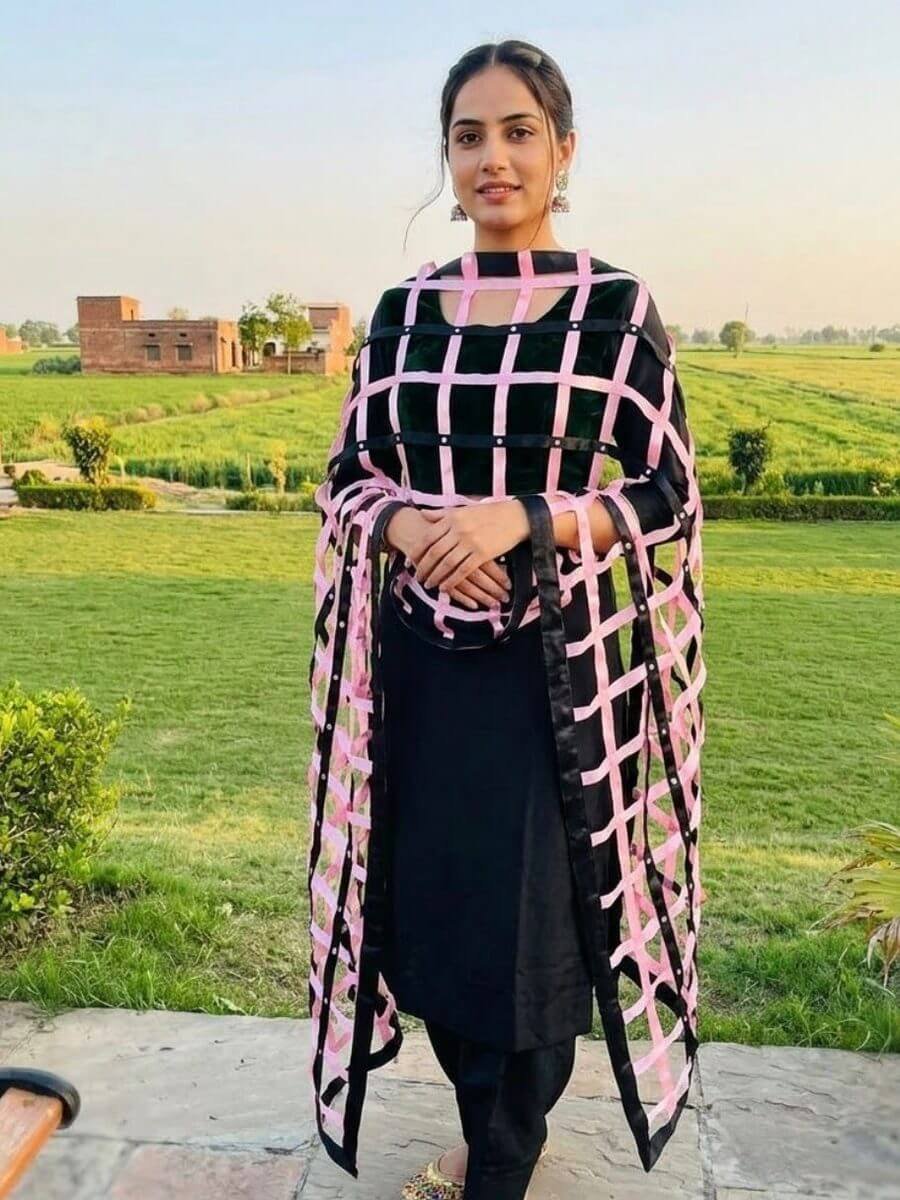 Rose-pink ribbon lattice dupatta worn over a black outfit